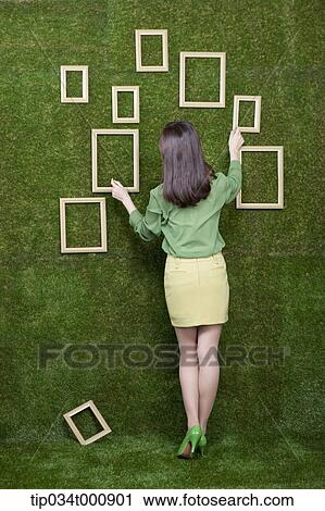 A woman looking the frames on the green wall View Large Photo Image Stock Image - A woman looking the frames on the green wall. Fotosearch