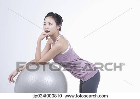 Stock Image - A woman resting on a gym ball. Fotosearch
