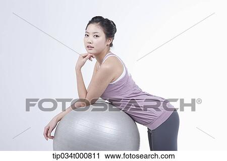 Stock Image - A woman resting on a gym ball. Fotosearch