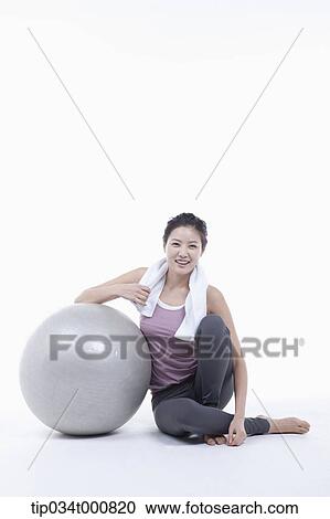 Stock Image - A woman resting on a gym ball. Fotosearch