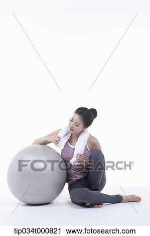 Stock Image - A woman resting on a gym ball. Fotosearch