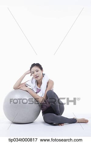A woman resting on a gym ball View Large Photo Image Stock Photo - A woman resting on a gym ball. Fotosearch