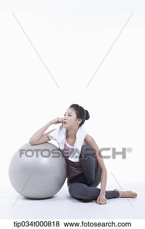 Stock Photo - A woman resting on a gym ball. Fotosearch