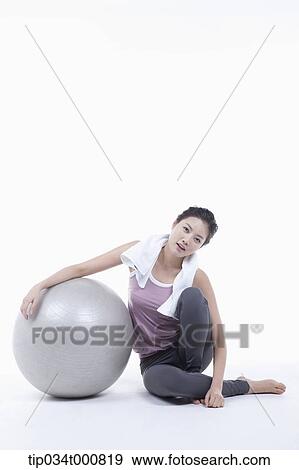 Stock Photo - A woman resting on a gym ball. Fotosearch