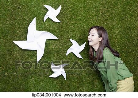 Picture - A woman smiling at the white pinwheels. Fotosearch