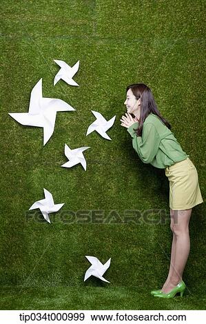 Stock Photo - A woman smiling at the white pinwheels. Fotosearch