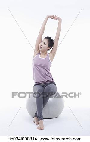 A woman stretching on a gym ball View Large Photo Image Picture - A woman stretching on a gym ball. Fotosearch