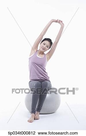 Stock Image - A woman stretching on a gym ball. Fotosearch