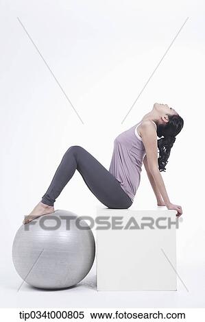 Stock Photography - A woman stretching with a gym ball. Fotosearch