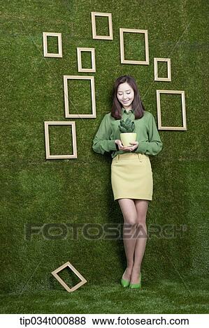 A woman with a green cactus pot View Large Photo Image Stock Photo - A woman with a green cactus pot. Fotosearch