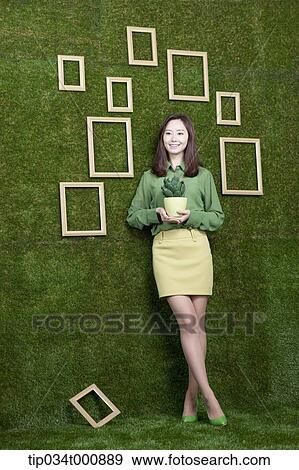 Stock Photo - A woman with a green cactus pot. Fotosearch