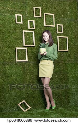 Stock Photograph - A woman with a green cactus pot. Fotosearch