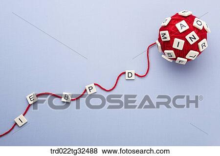 Stock Photo - Alphabet blocks on a ball of red wool . Fotosearch