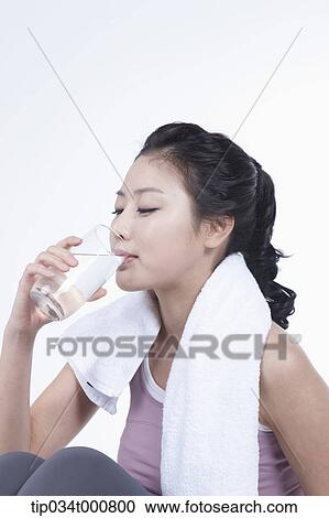 Stock Image - An excersing woman taking a break with water. Fotosearch