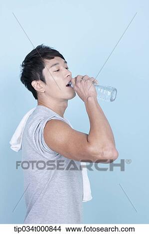 Picture - An exercising man drinking the water. Fotosearch