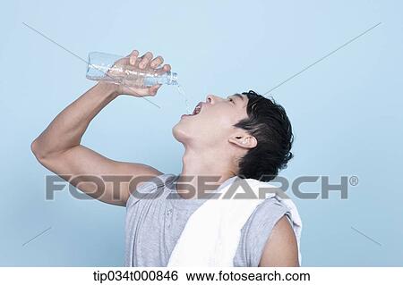 Stock Photograph - An exercising man drinking the water. Fotosearch