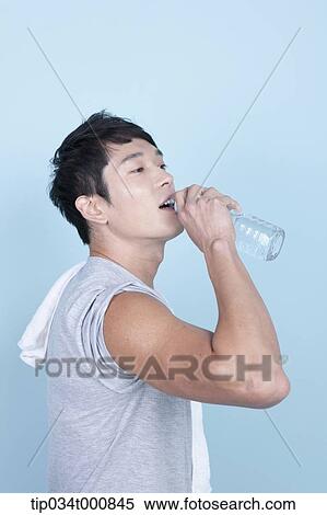Stock Photography - An exercising man drinking the water. Fotosearch
