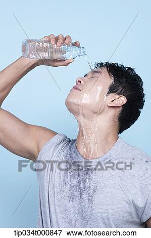 Stock Photo - An exercising man pouring the water on his face. Fotosearch