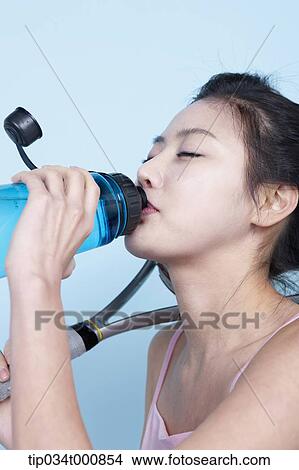 An exercising woman drinking the water View Large Photo Image Picture - An exercising woman drinking the water. Fotosearch