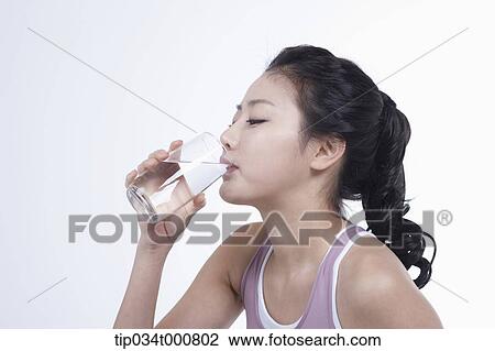 Stock Image - An exercising woman drinking the water. Fotosearch