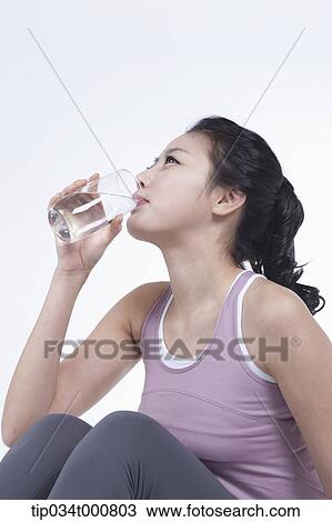 Stock Image - An exercising woman drinking the water. Fotosearch