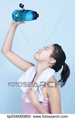 An exercising woman pouring the water on her face View Large Photo Image Stock Photography - An exercising woman pouring the water on her face. Fotosearch