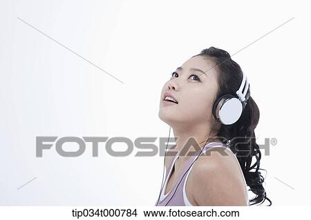 Picture - An exercising woman taking a break with music. Fotosearch