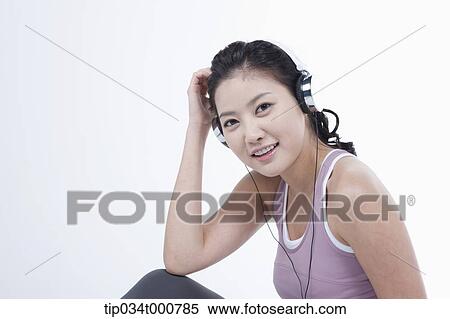 Stock Photography - An exercising woman taking a break with music. Fotosearch