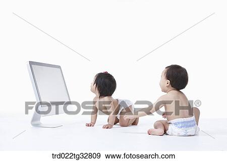 Stock Photo - Babies around the monitor. Fotosearch