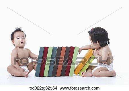 Picture - Babies sitting around the books. Fotosearch