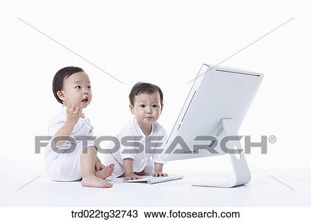 Babies sitting with a computer View Large Photo Image Stock Image - Babies sitting with a computer. Fotosearch