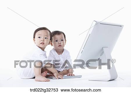 Stock Image - Babies sitting with a computer. Fotosearch