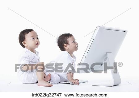 Babies sitting with a computer View Large Photo Image Stock Photo - Babies sitting with a computer. Fotosearch
