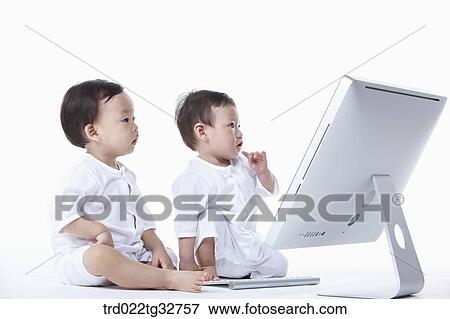 Babies sitting with a computer View Large Photo Image Stock Photo - Babies sitting with a computer. Fotosearch