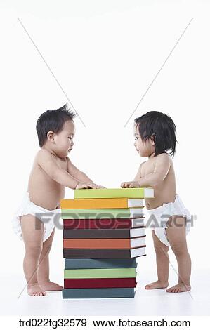 Stock Photo - Babies standing up around the books. Fotosearch