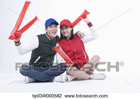 Stock Image - Baseball supporters with cheering tools. Fotosearch