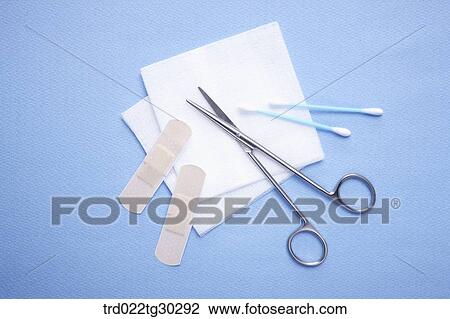 Stock Image - Blue cotton swaps, bandages, pieces of cotton, and scissors. Fotosearch