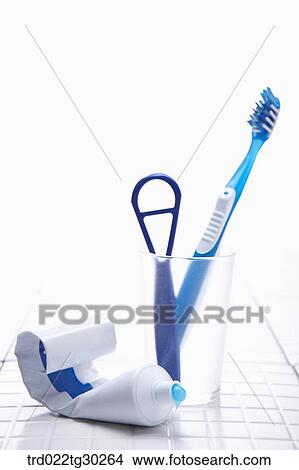Picture - Blue tooth brush, tongue cleaner in cup and tooth paste. Fotosearch