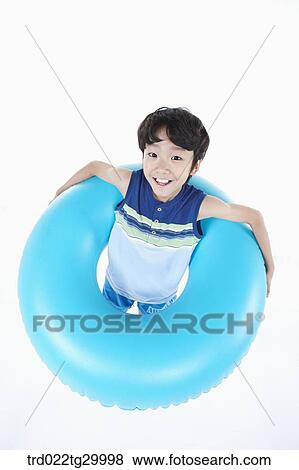 Stock Photo - boy is standing with holding beach ball. Fotosearch