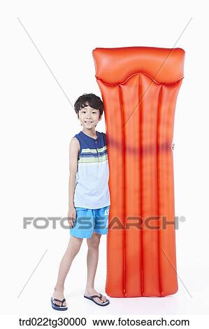 Stock Image - boy is standing with holding bed of tube. Fotosearch