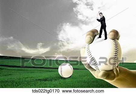 Stock Image - business man is holding bat on the baseball which was hold by someone's hand. Fotosearch
