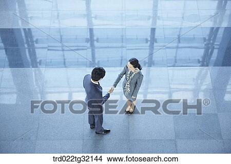 Picture - Business partners shaking hands together. Fotosearch