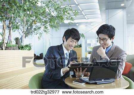 Stock Photo - Businessmen discussing the schedule. Fotosearch