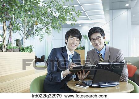 Stock Photo - Businessmen discussing the schedule. Fotosearch