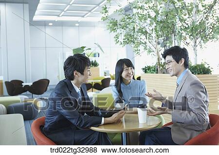 Stock Photo - Businessmen having a talk in the lounge. Fotosearch