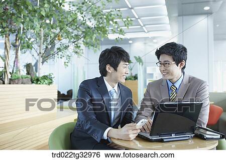 Stock Photograph - Businessmen having a talk in the lounge. Fotosearch