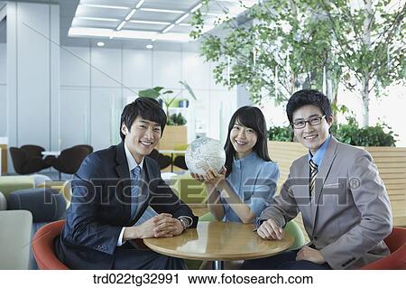 Stock Image - Businessmen having a talk with the globe. Fotosearch