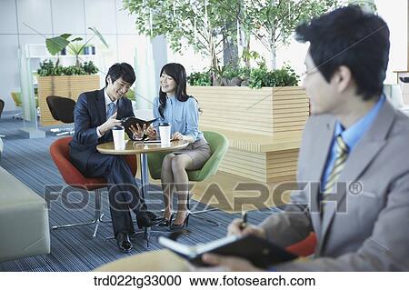 Stock Image - Businessmen holding the planner in the lounge. Fotosearch