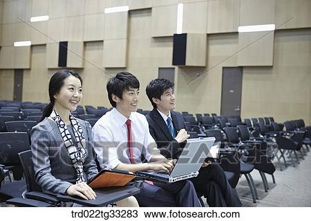 Stock Image - Businessmen listening to the seminar in the auditorium. Fotosearch