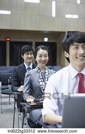Stock Image - Businessmen listening to the seminar in the auditorium. Fotosearch